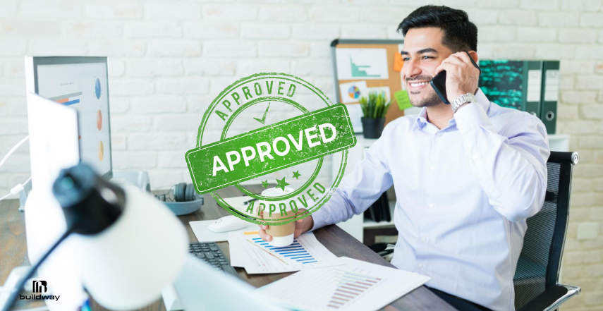 Office professional smiling while talking on the phone at a desk with paperwork and an “approved” stamp graphic overlay.