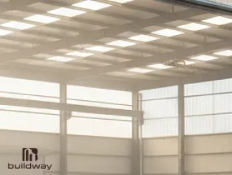 Interior of an I-beam steel structure featuring translucent light-transmitting roof panels that allow natural daylight to illuminate the building while maintaining energy efficiency and durability.